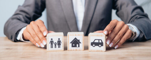 horizontal crop of woman touching wooden cubes with family, car and house